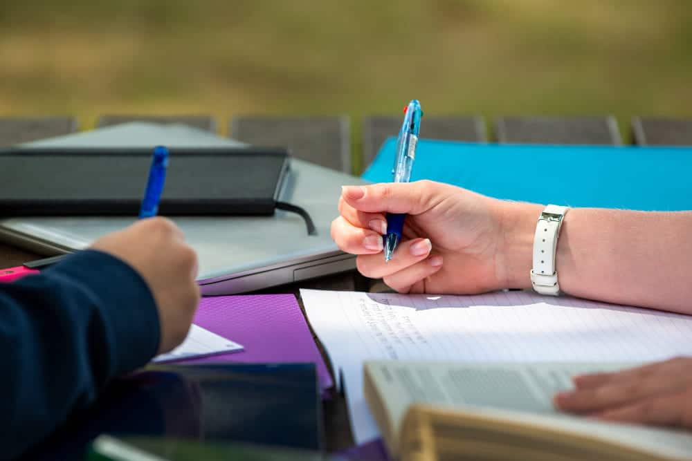 mano escribiendo cuaderno clase estudiante colegio